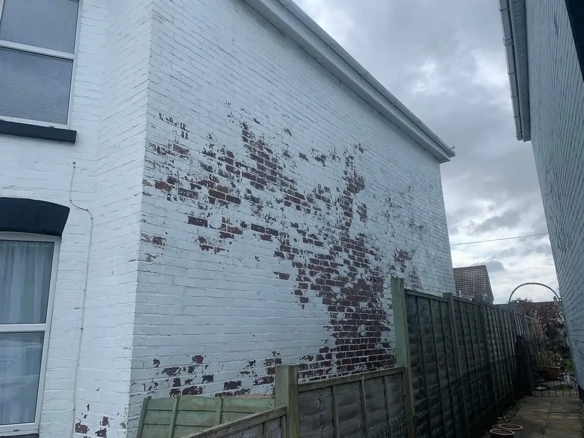 Peeling paint on a brick wall before redecoration in Charlestown